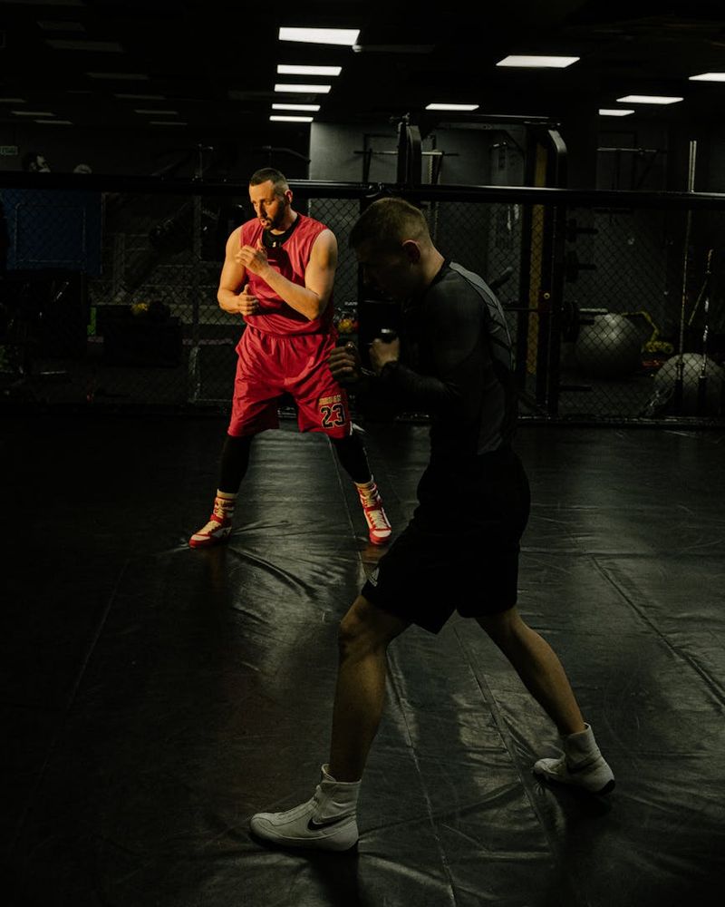 Person doing dynamic cardio movements in a dark studio setting.